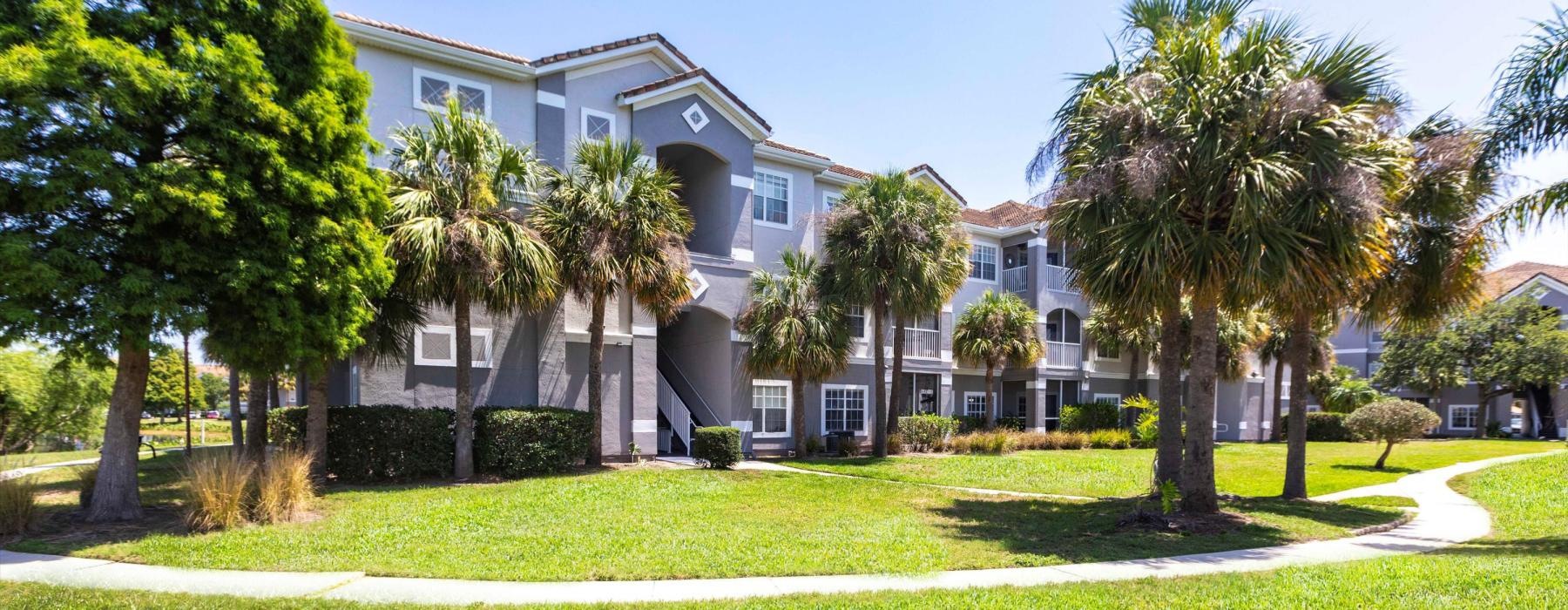 a building with palm trees and grass