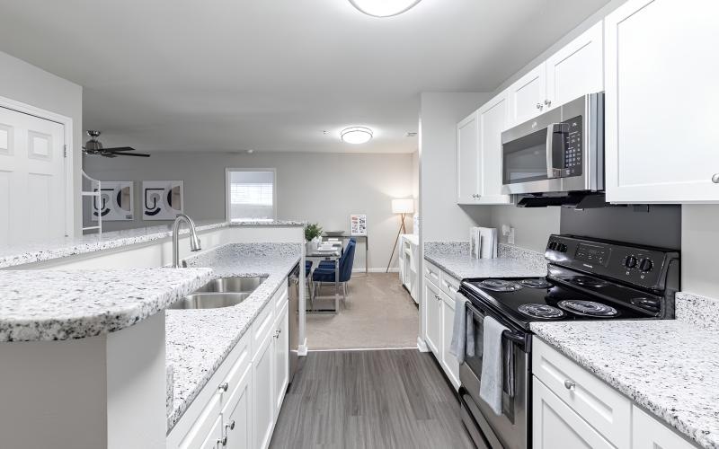 a kitchen with white cabinets and granite countertops