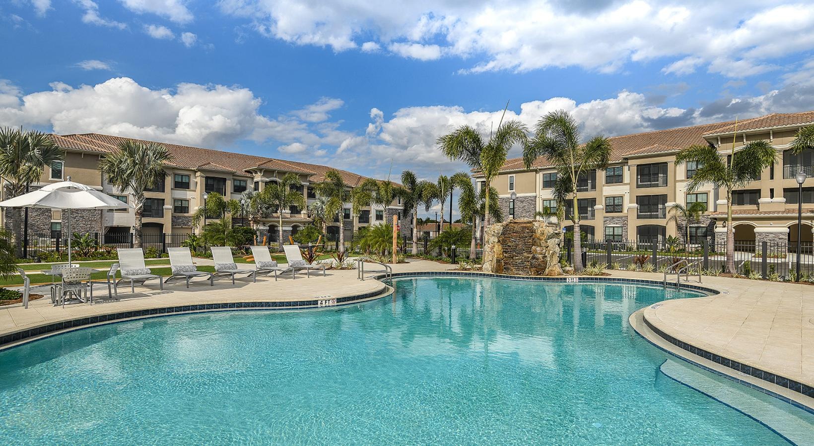 Resort-style swimming pool with waterfall