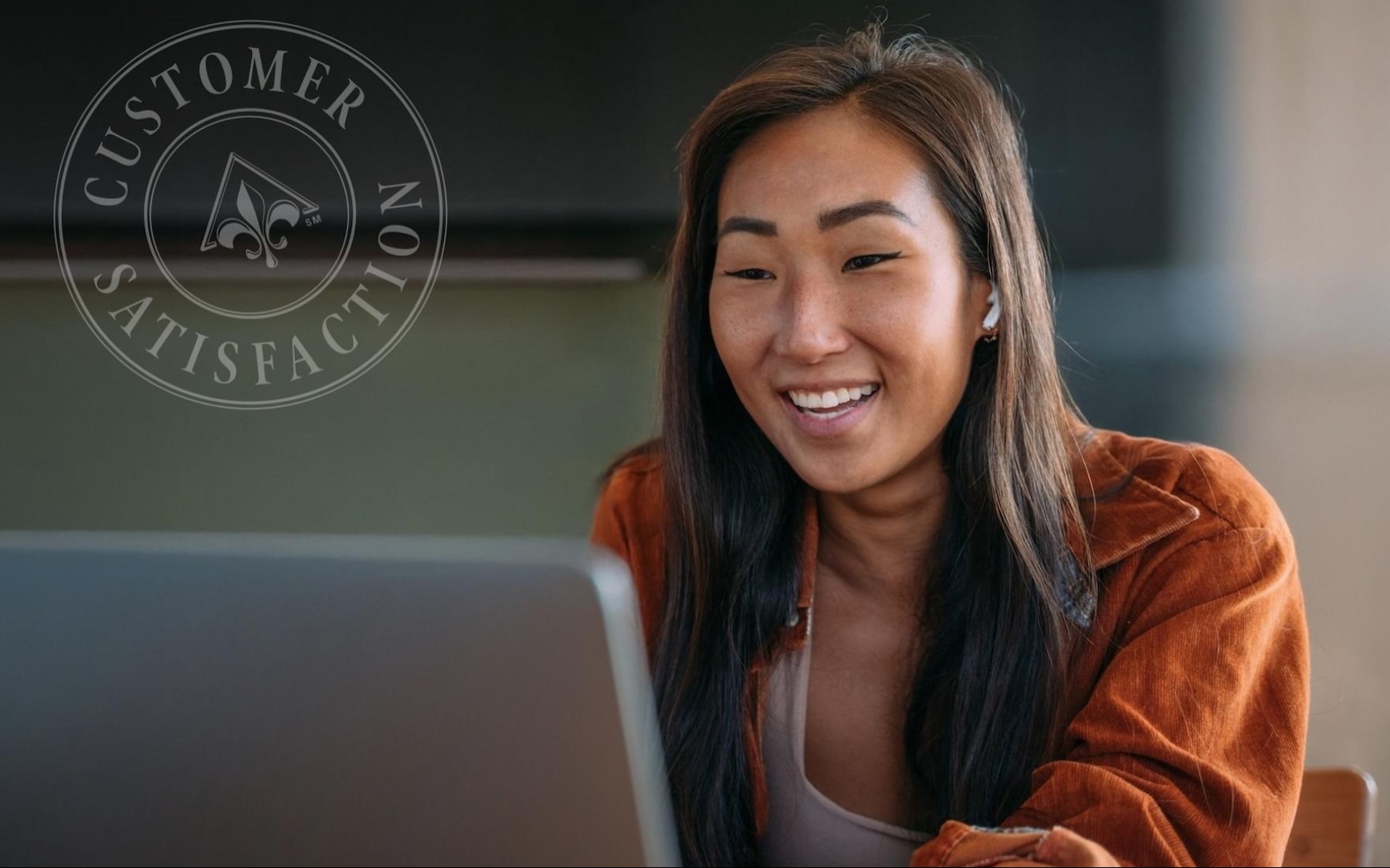 a woman smiling while working on a laptop