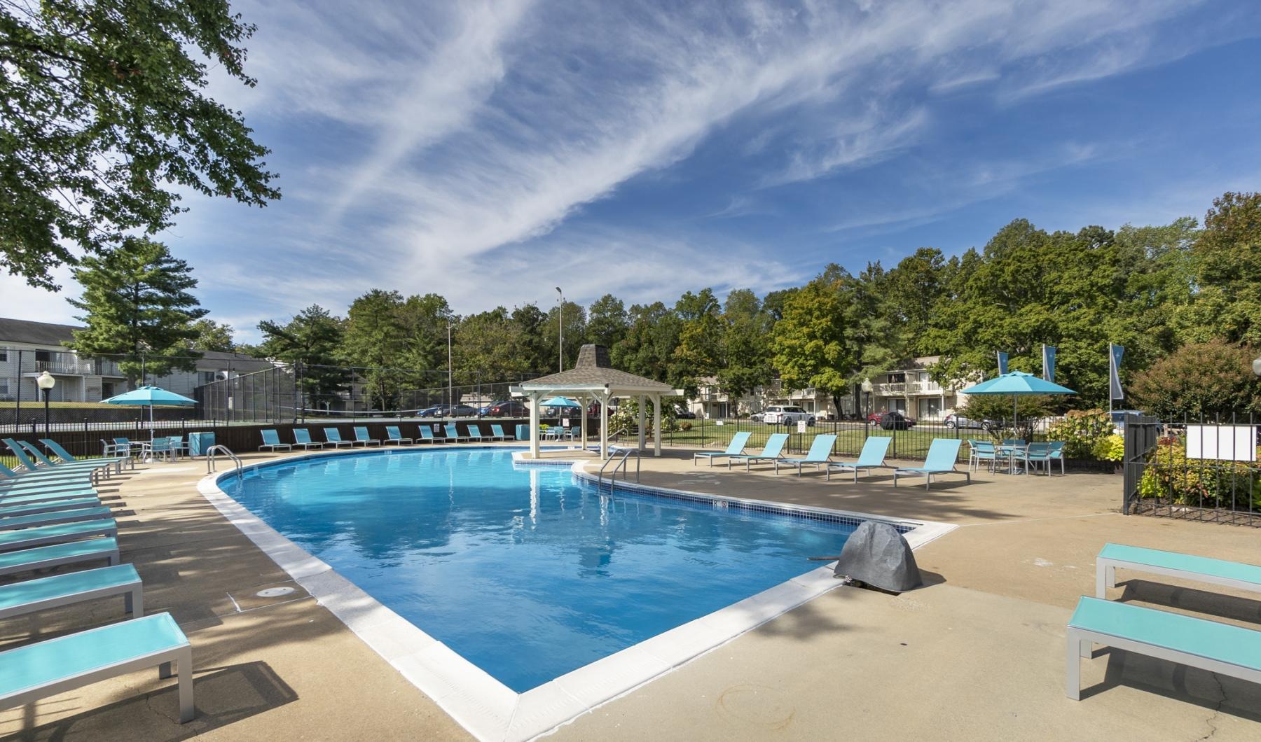 a swimming pool with lounge chairs around it