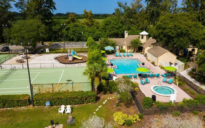 a large courtyard with a swimming pool and tennis court