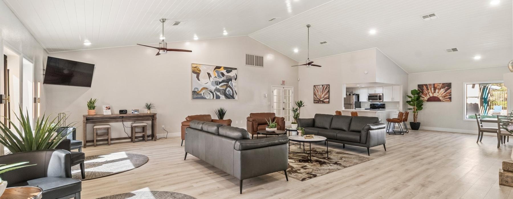 a large lounge room with a wood floor, sitting area and a tv