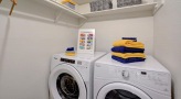 Laundry area with side-by-side washer and dryer and extra shelving
