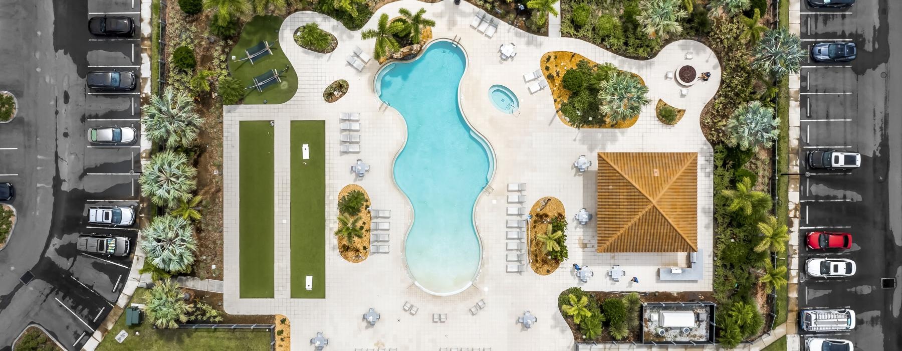 aerial view of a community with a pool and parking lot