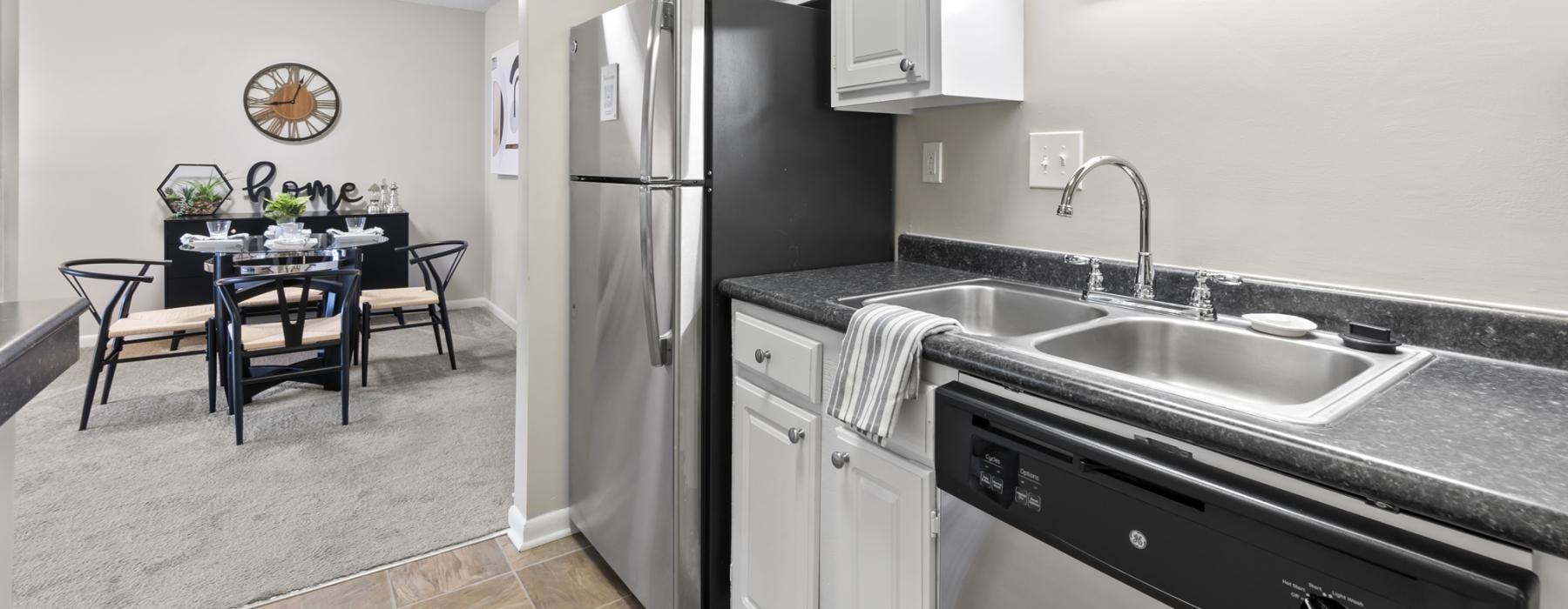 a kitchen with a fridge leading into a room with a dining table