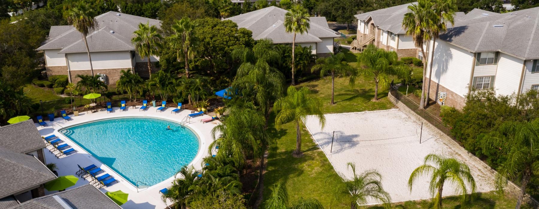 a pool surrounded by trees and buildings