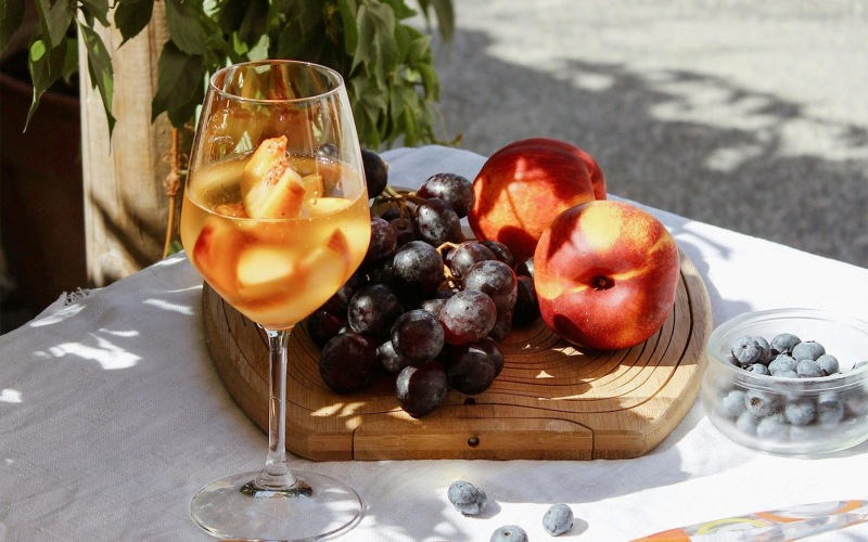 a board of fruit and a glass of wine