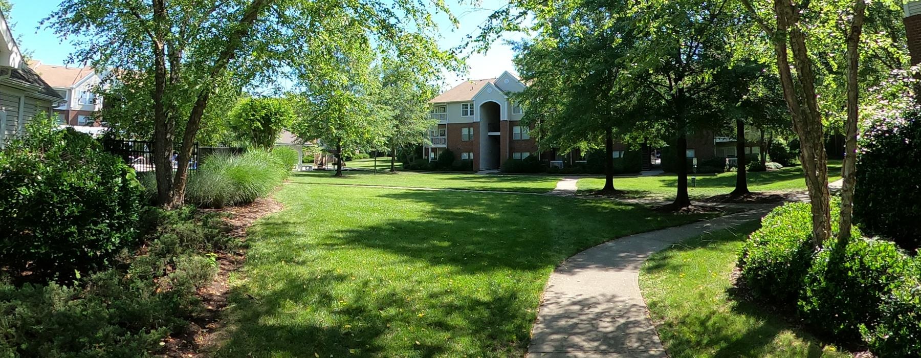 a path through a grass lawn leading to a building