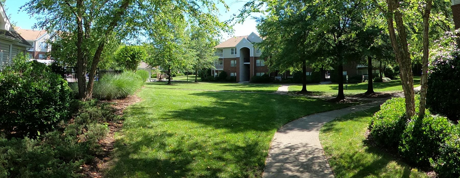 a path through a grass lawn leading to a building