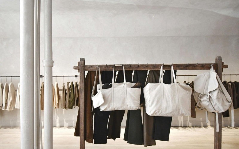 a row of clothes and bags on a rack