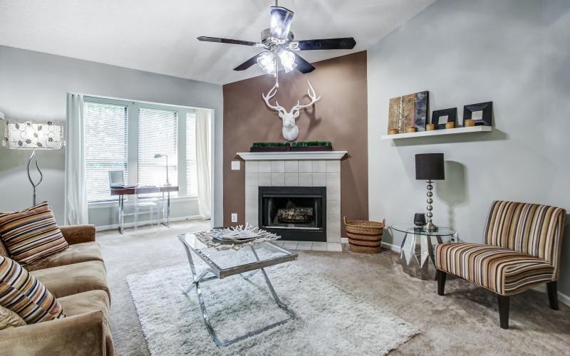 a living room with a fireplace a couch and a large window