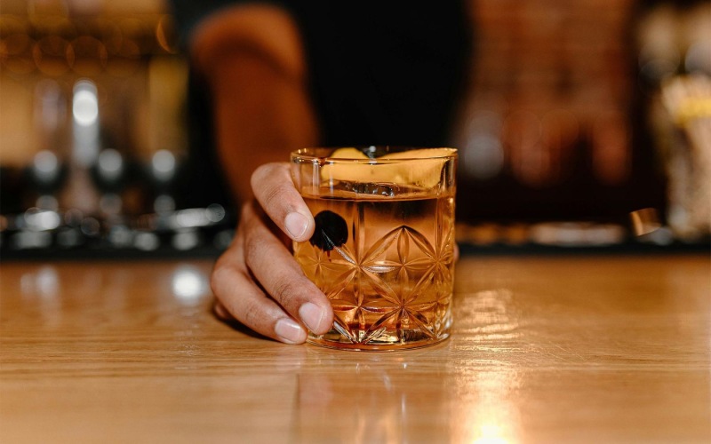 a hand holding holding a cocktail glass