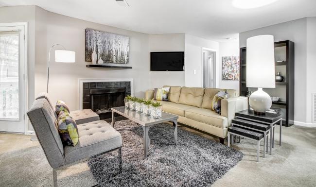 a living room with a fireplace, couch, chairs and a tv