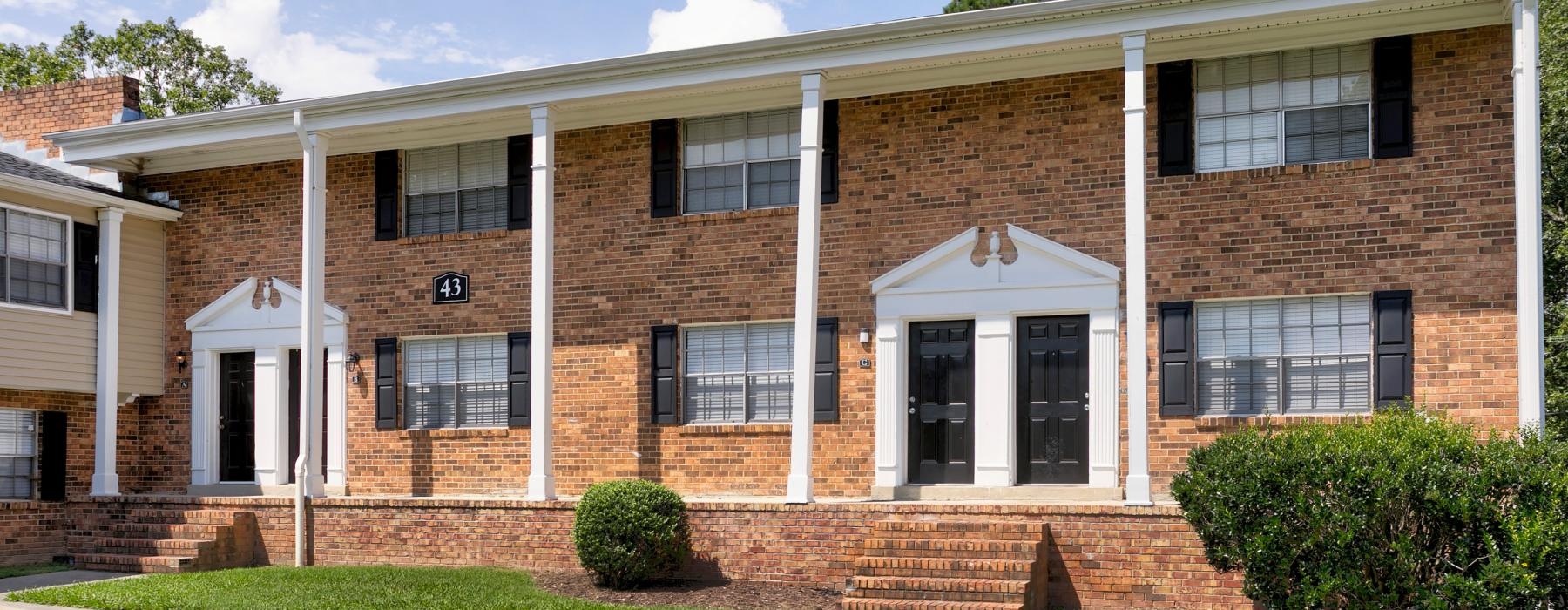a brick building with a lawn in front of it