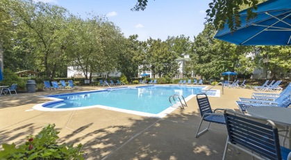 Resort-style swimming pool plaza with lounge seating and umbrellas