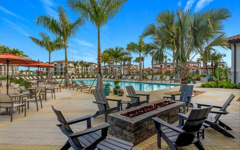 a pool with chairs and tables next to it