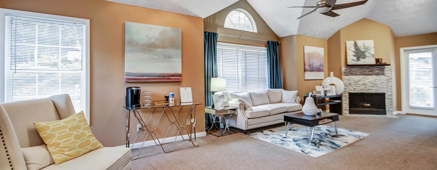 a large living room with a fireplace and seating