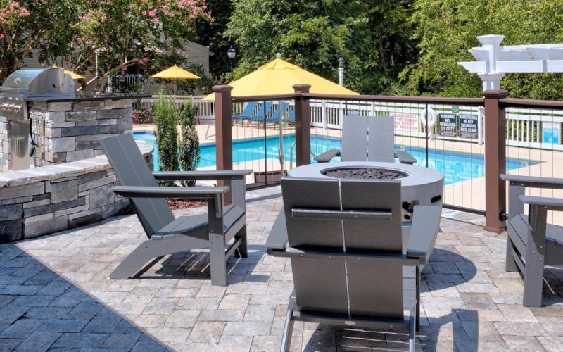 a patio with benches and a grill
