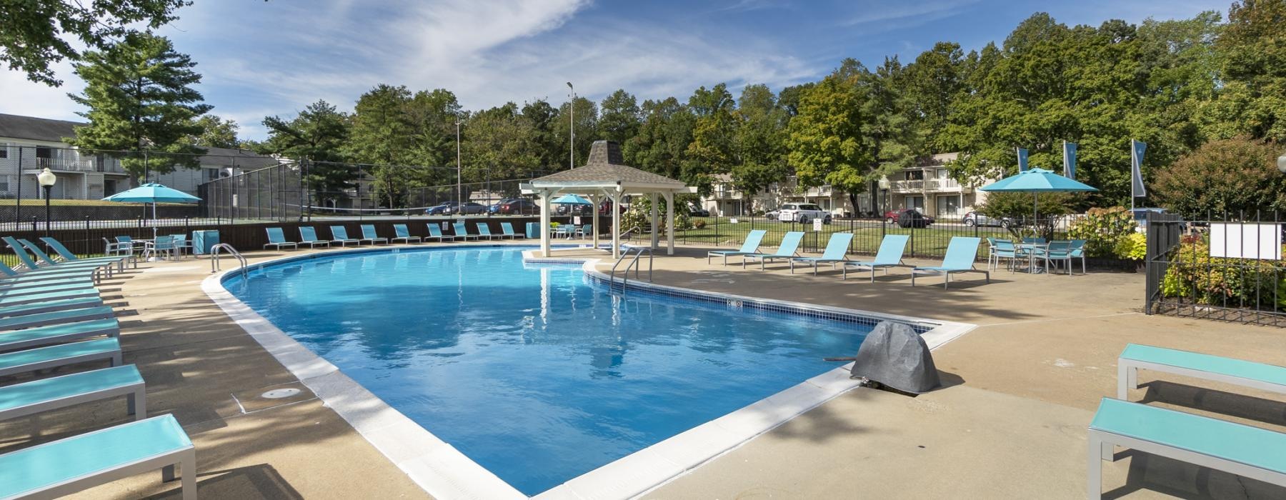 a swimming pool with lounge chairs around it