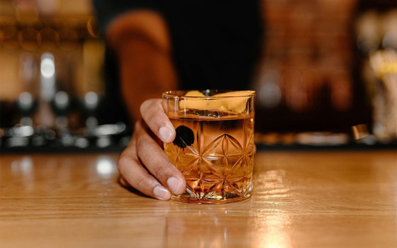 a hand holding holding a cocktail glass