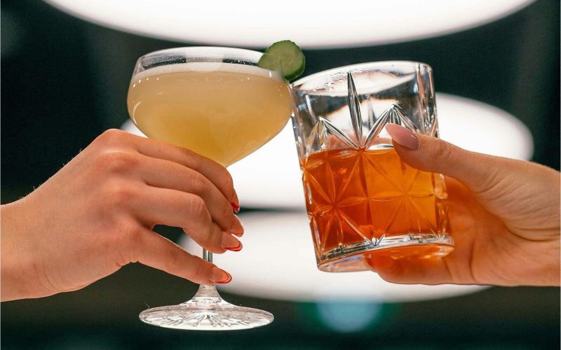 hands holding glasses with cocktails