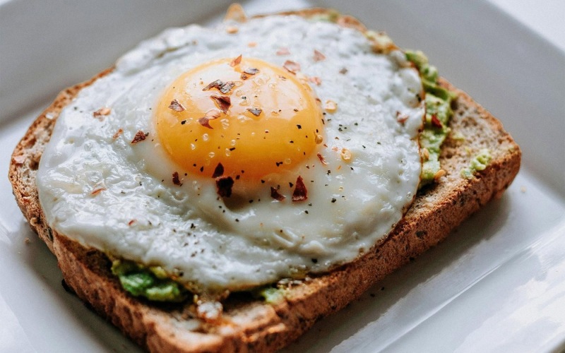 a breakfast sandwich with an egg on top
