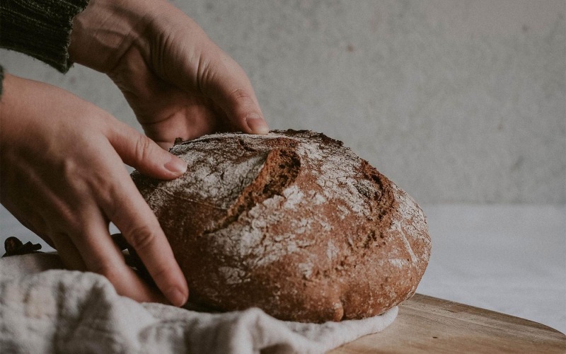a person holding a loaf of bread