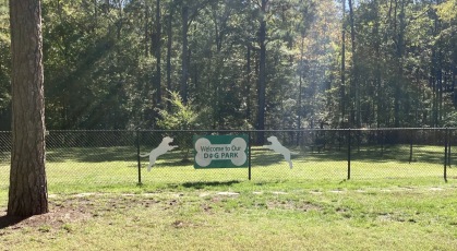 Fenced in bark park shaded by mature trees 