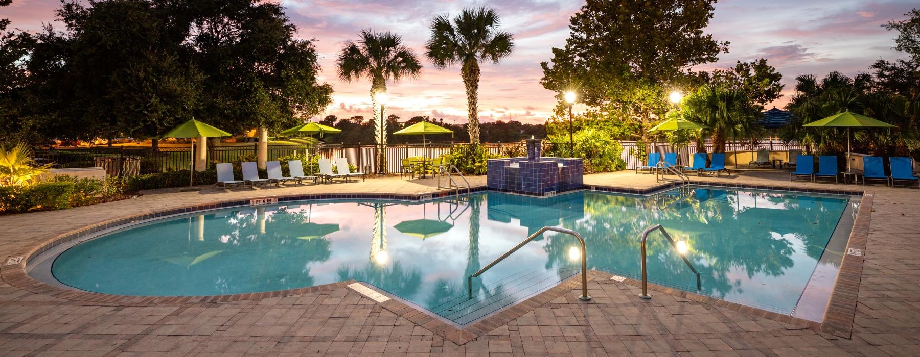 a pool with a sunset in the background