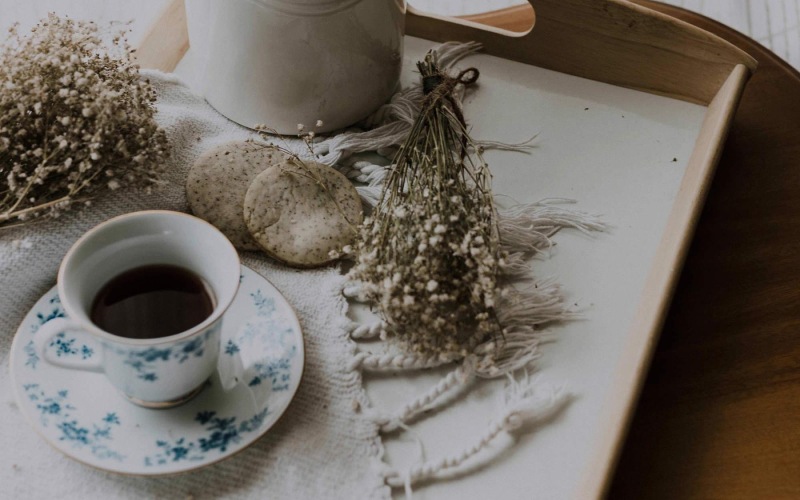 tea and cookies on a serving tray with baby's breath