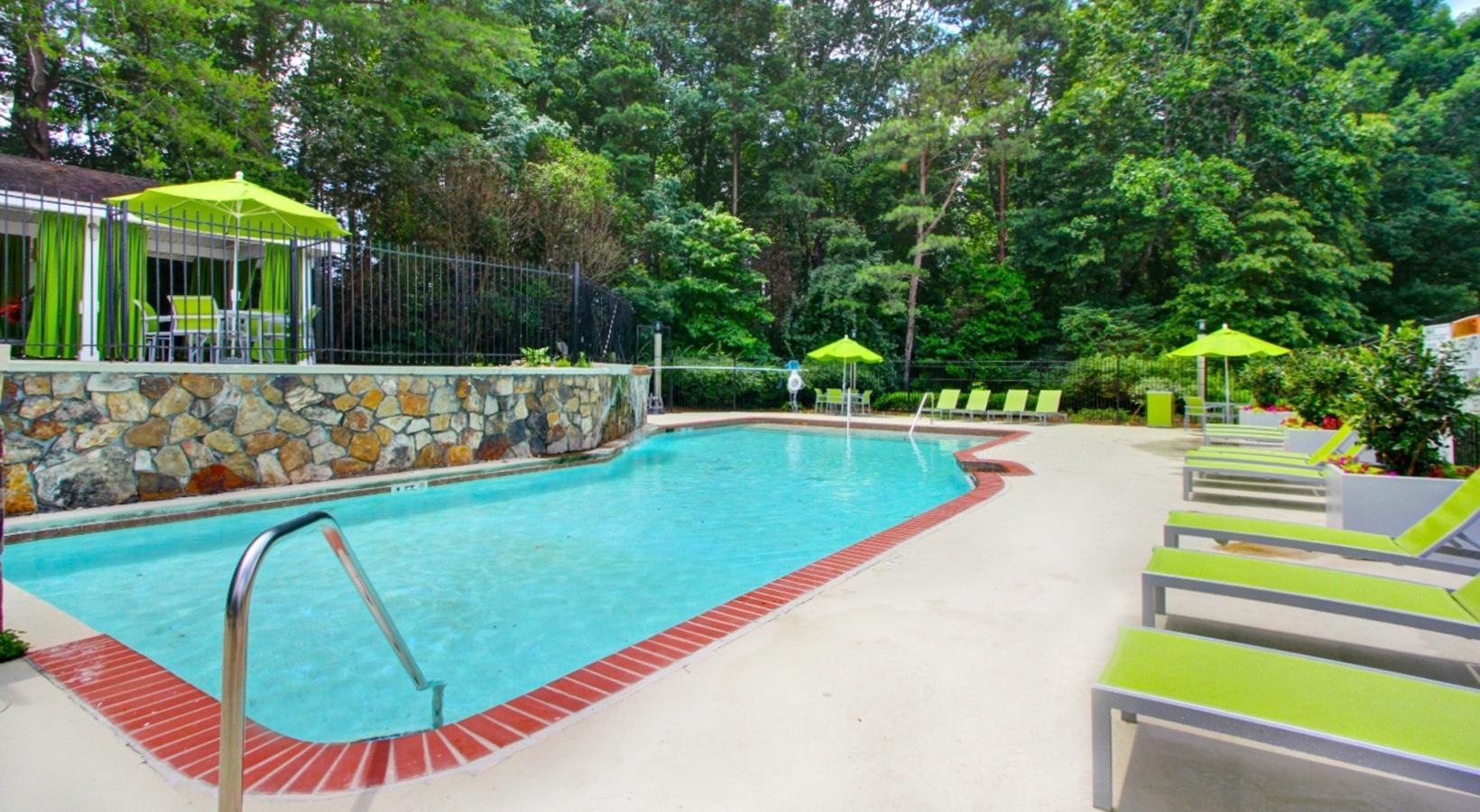 Pool with adjustable lounge chairs and shaded tables