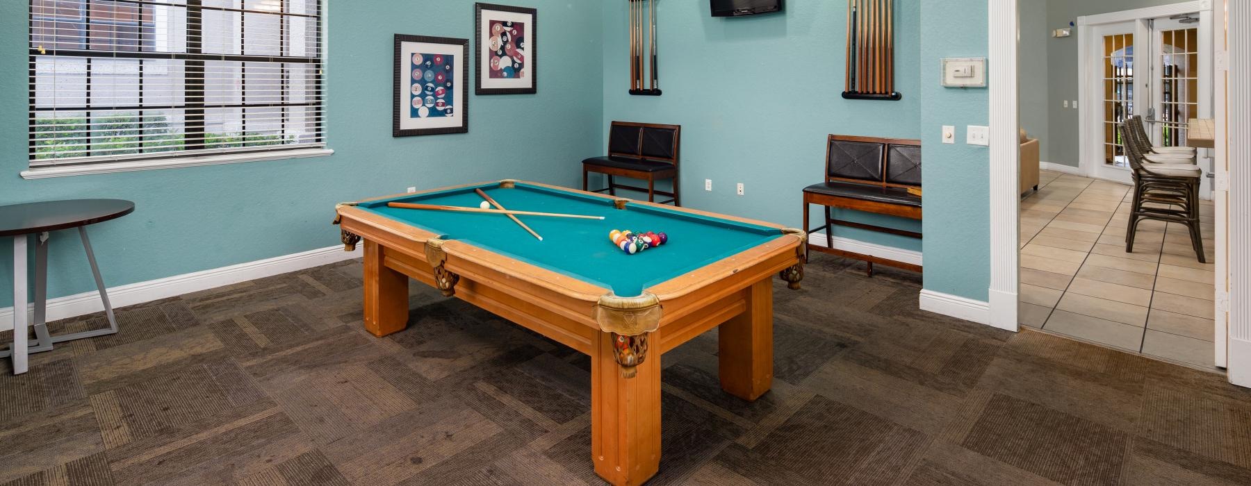 a clubroom with a pool table and chairs