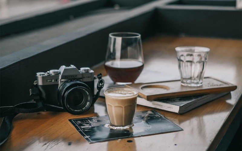 a camera and cup of coffee on a table