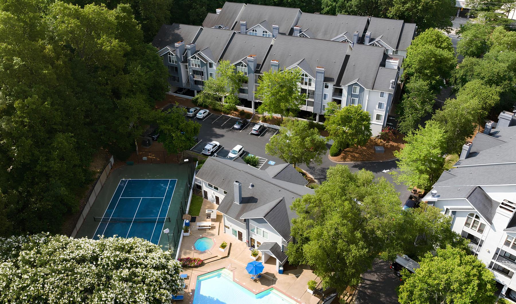 a large building with a pool and trees around it