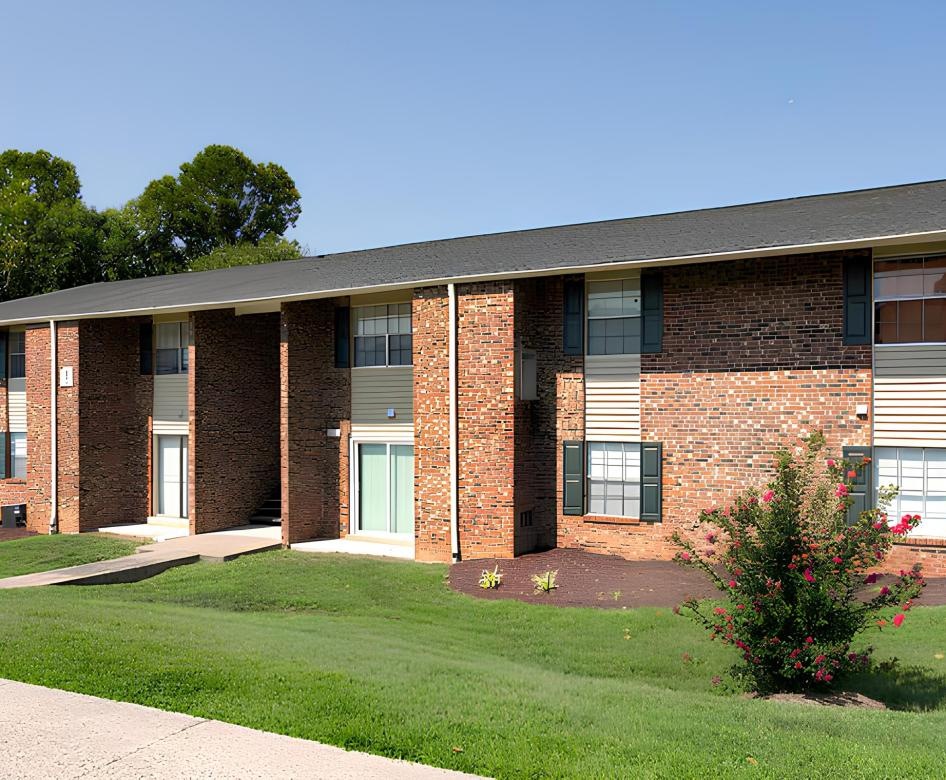 a brick building with a green lawn
