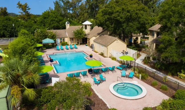 a pool by a club house and trees