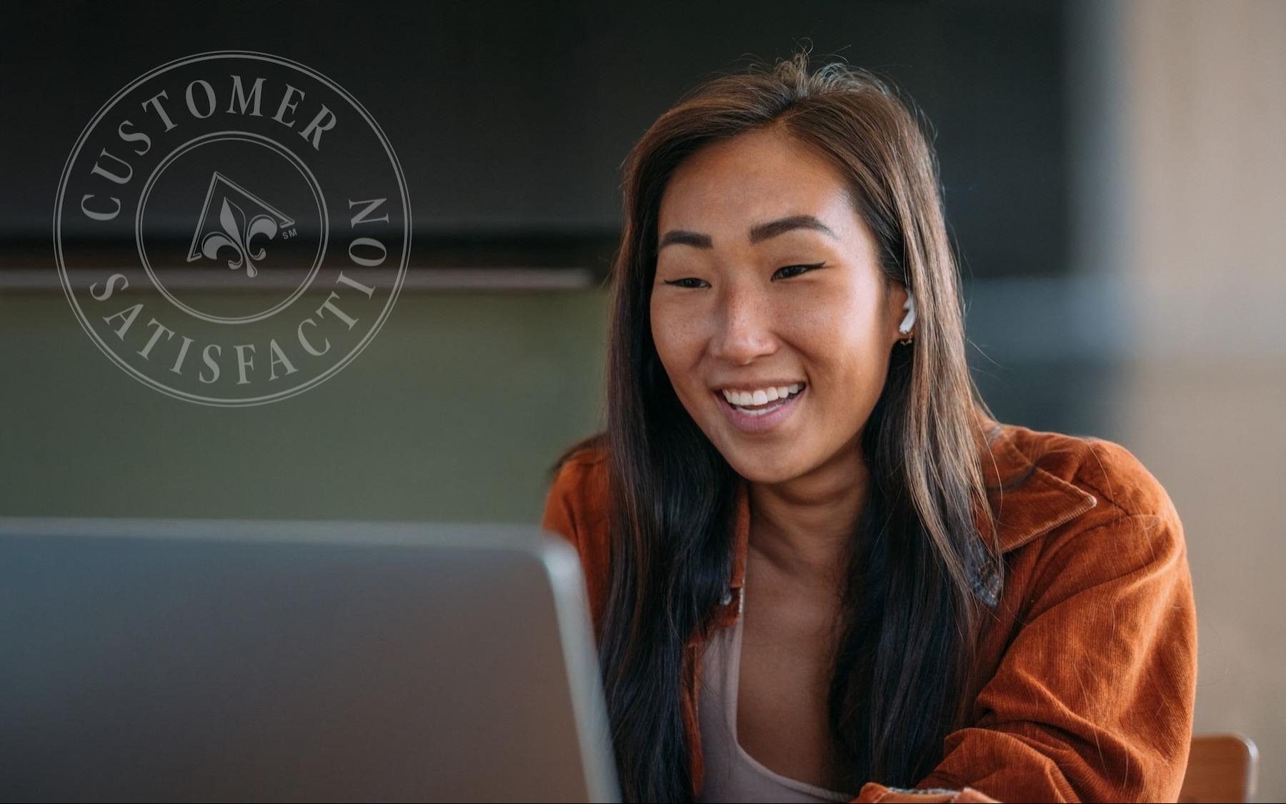 a woman smiling at the camera on a laptop