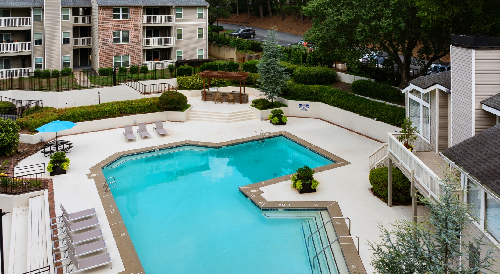 Sparkling pool with gas grills under a wooden pergola