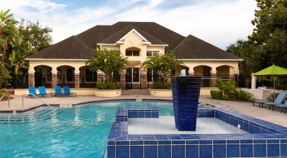 Outdoor pool with water feature situated behind resident clubhouse