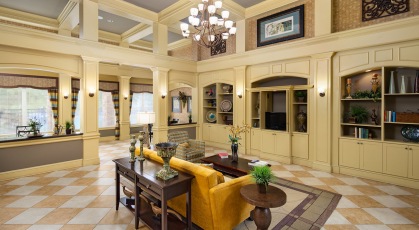 Spacious, brightly lit resident's lounge with high, ceilings, tv and seating