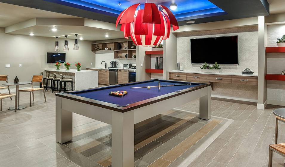 billiards table and kitchen in well lit clubhouse