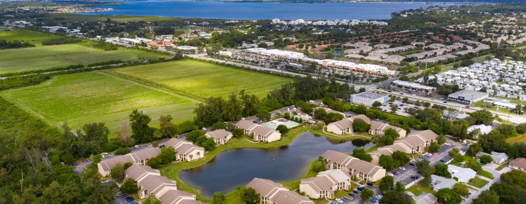 a building complex next to a body of water and a town