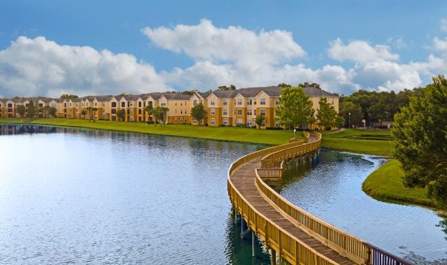 a wooden walking bridge over a pond