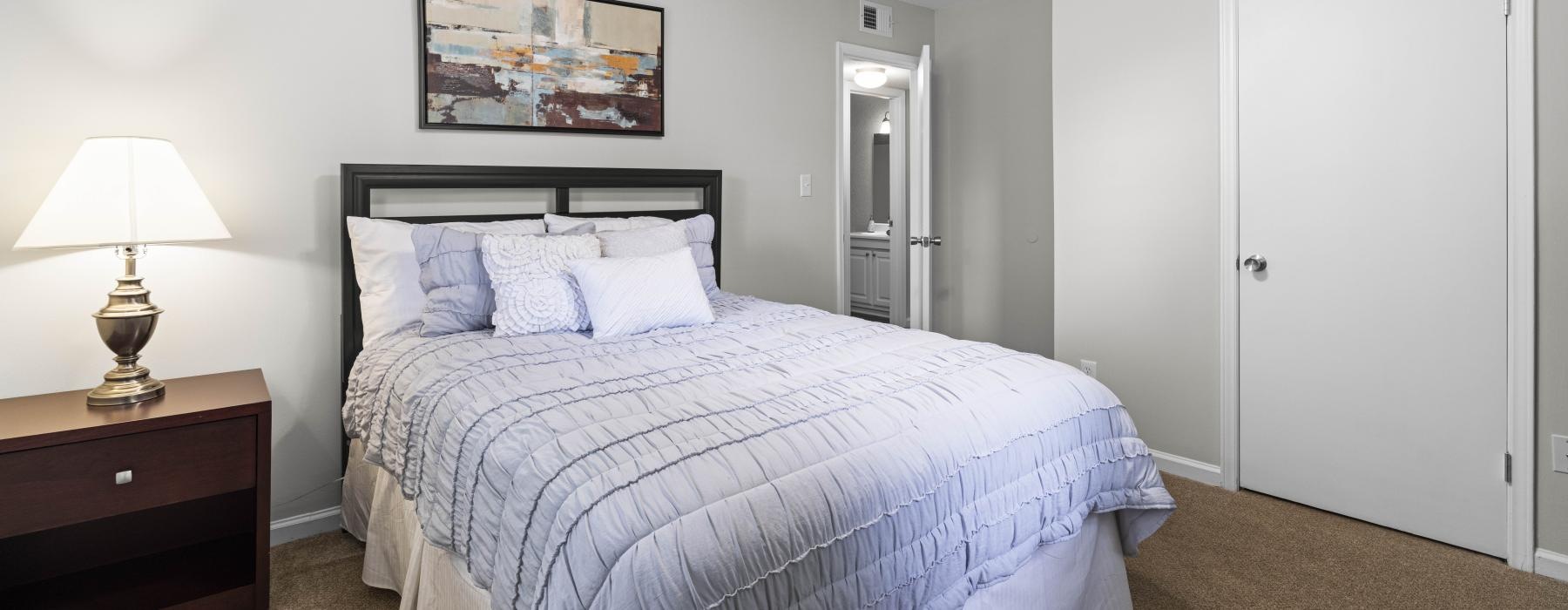 a bedroom with a bed and a lamp