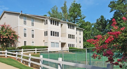 Fenced in complex with clean, lush landscaping and mature trees