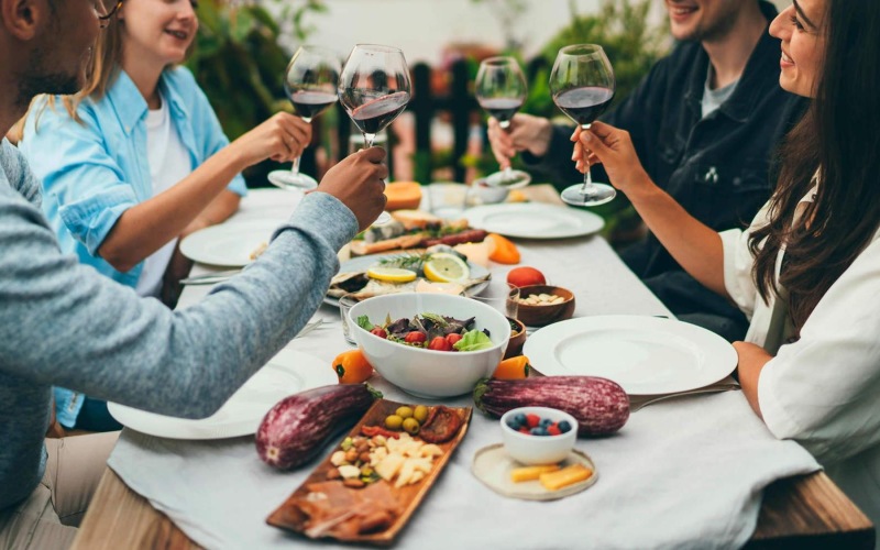a group of people having a meal around an outdoor table