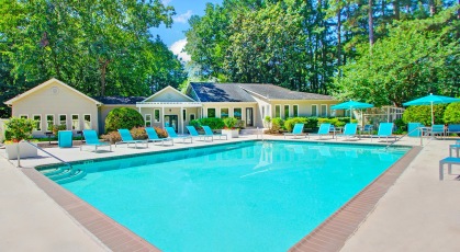 Swimming pool area with umbrella shaded tables and chairs