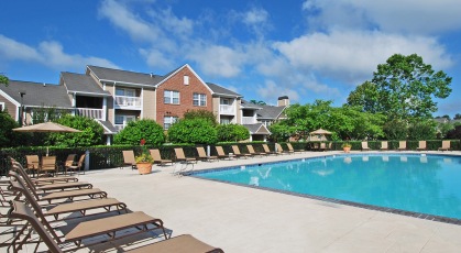 Resort-style swimming pool plaza with lounge seating and umbrellas