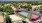 Arial view of the property's sand volleyball and tennis courts with views of the surrounding neighborhood